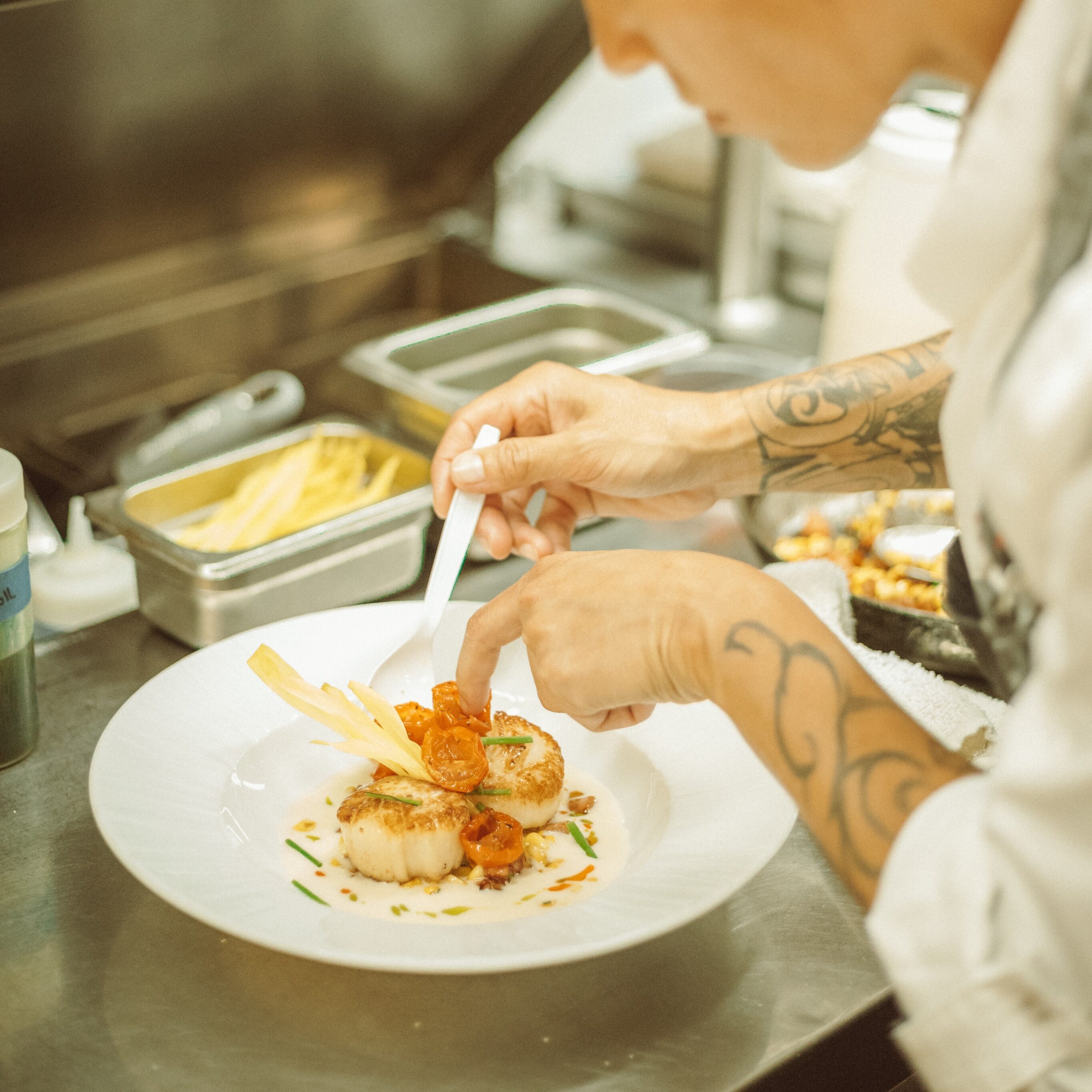 In the bustling professional kitchen, the chef meticulously plates a gourmet dish with the signature flair of Chef's Pa’ina.